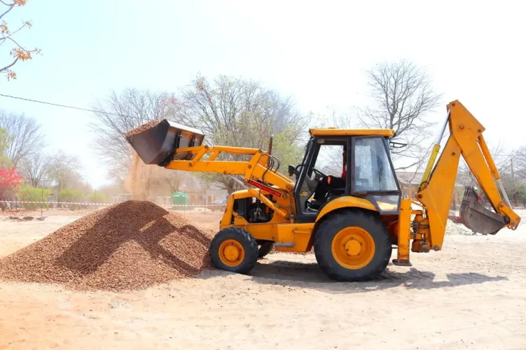 Excavator moving gravel during grading and site prep