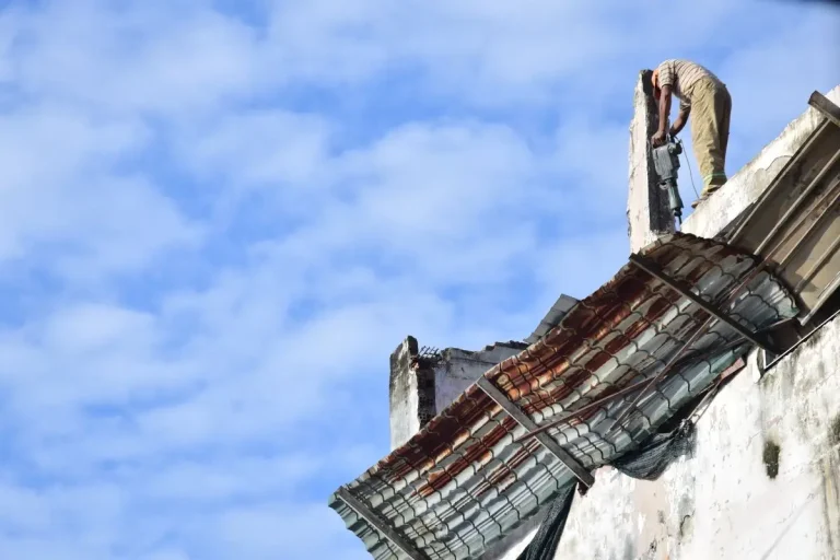 Demolition worker tearing down an old roof structure