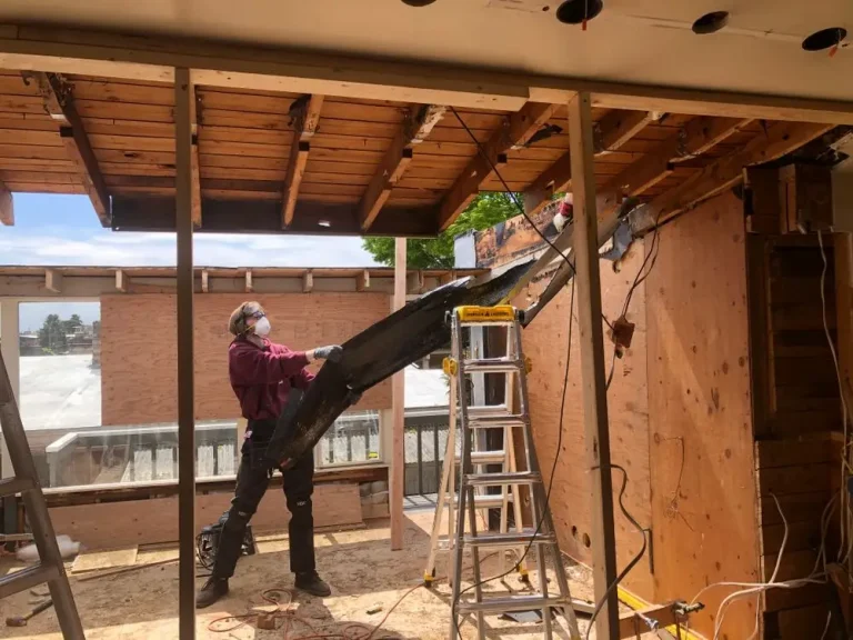 Worker gutting a home interior during a remodel